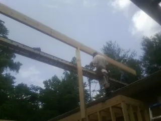 Carpenter setting a ridge beam over a new addition frame — Ice Dam Removal by Roofing Brothers in Elsinore