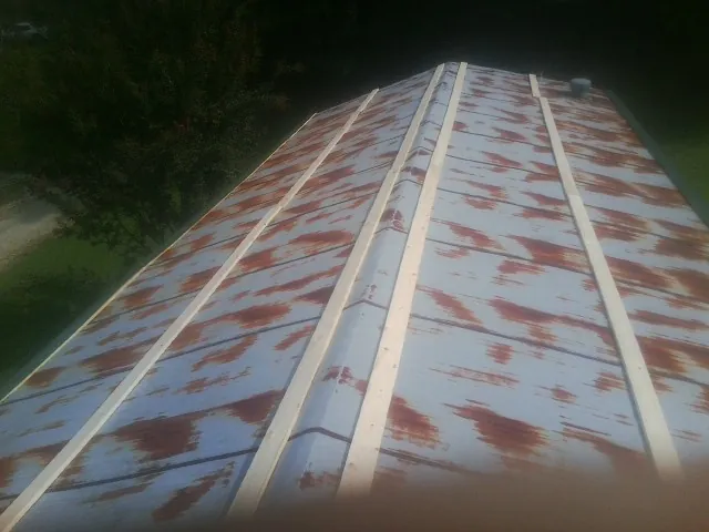 Rusted metal roof panels with new wood purlins before replacement — Storm Damage Roof Repair in Elsinore by Roofing Brothers