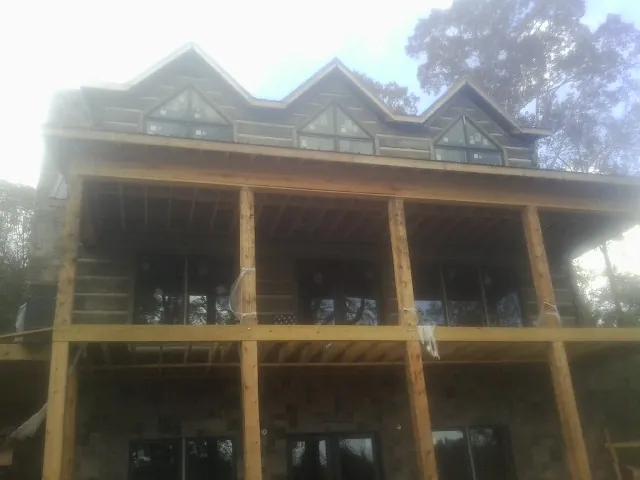 Dormers and porch framing on a large log home under construction — Roof Coating work by our crew in Elsinore